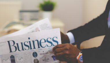 person wearing suit reading business newspaper