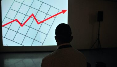 man wearing white top looking at projector graph screen